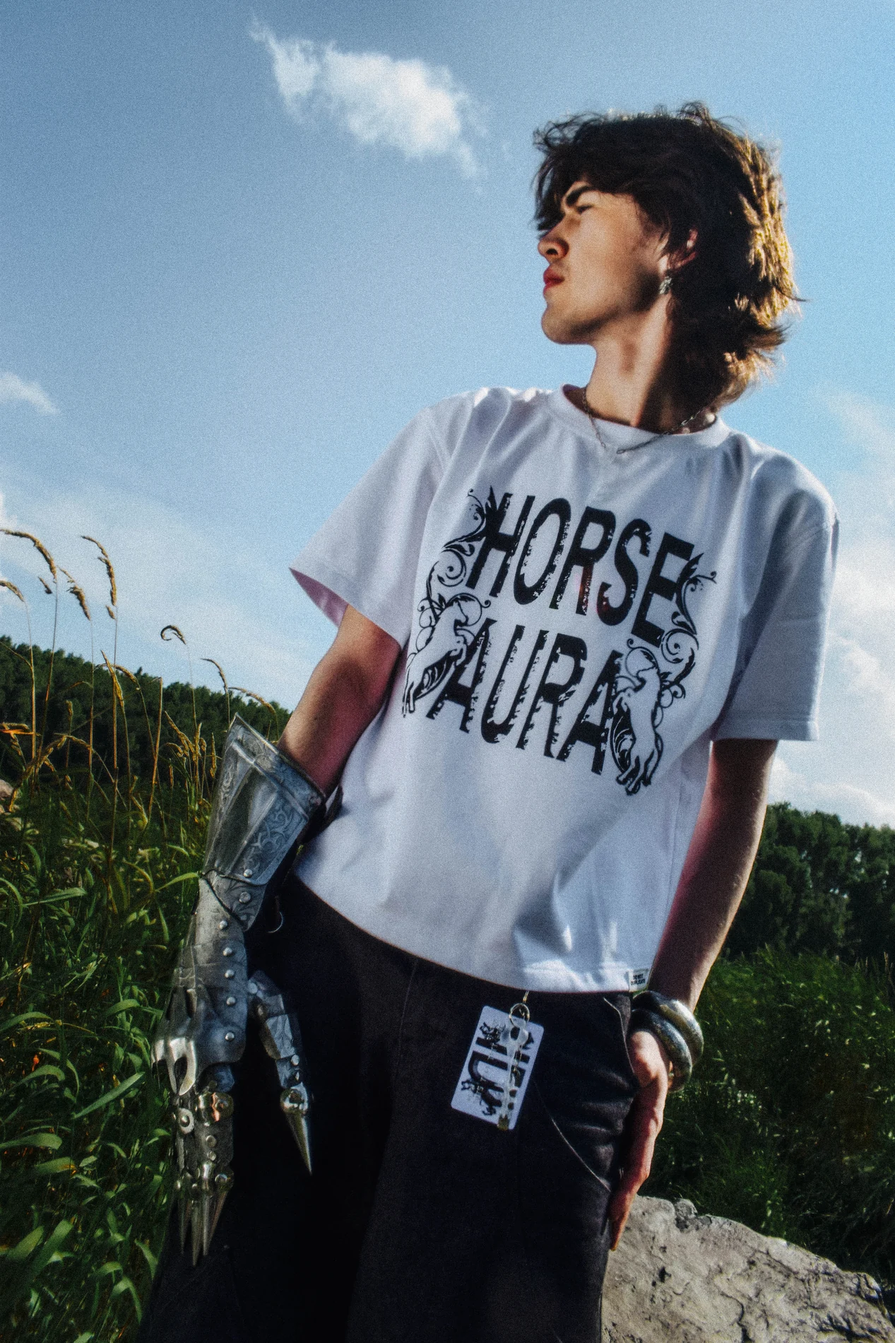 Model wearing the HORSE AURA T-shirt in an outdoor campaign image