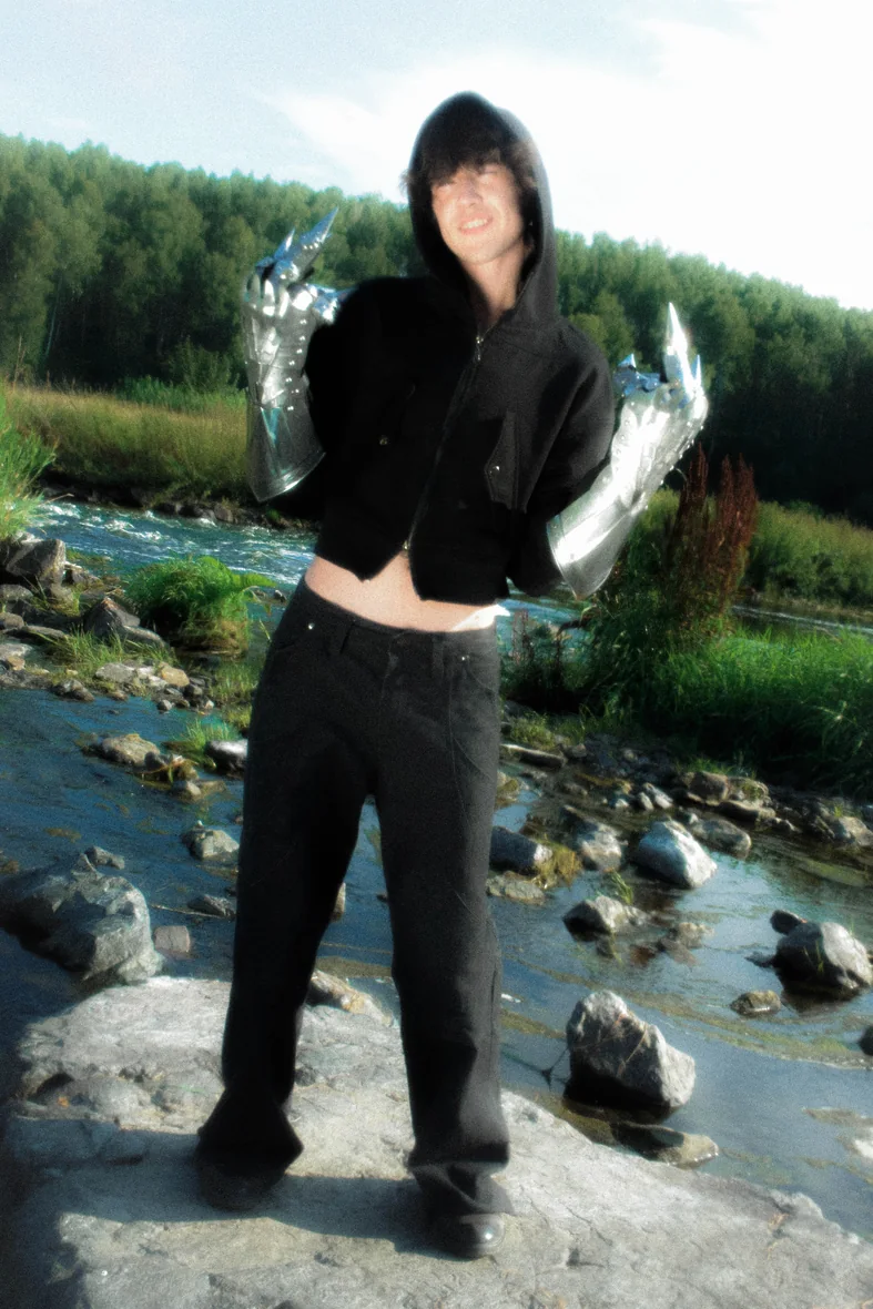 Model in the KEY hoodie standing in a river landscape